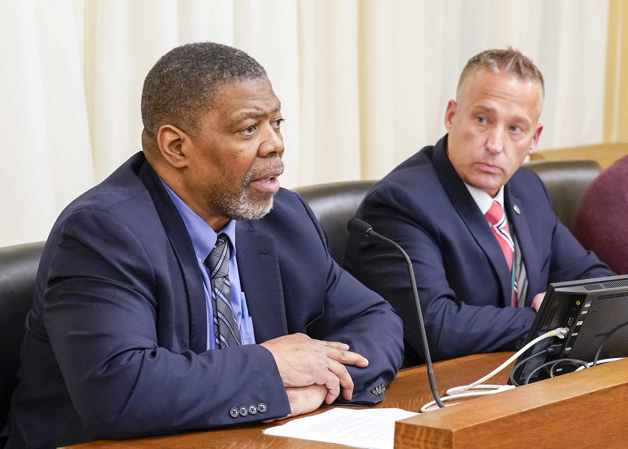 Timothy Childs, founder, innovator, and chief technology officer at Guardian School Security Systems, testifies April 8 in support of a bill sponsored by Rep. Ben Bakeberg, right, to establish a school safety threat assessment pilot project. (Photo by Andrew VonBank)